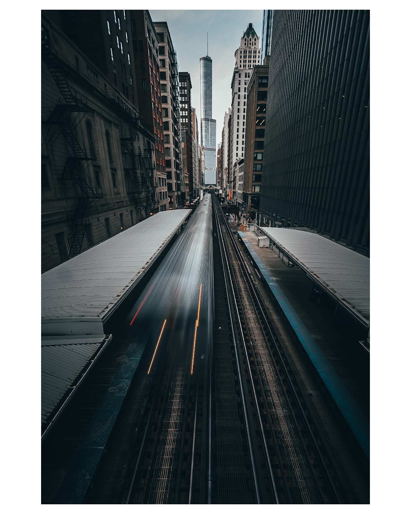 A Brown Line train moves between the buildings of the Loop.